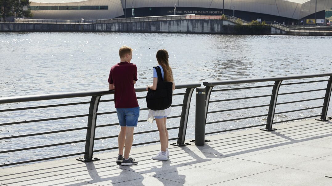 2 adults looking at the water outside the Vic building