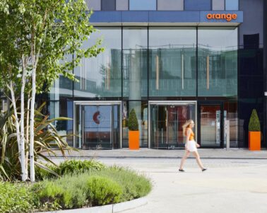 Women walking past the Orange building entrance
