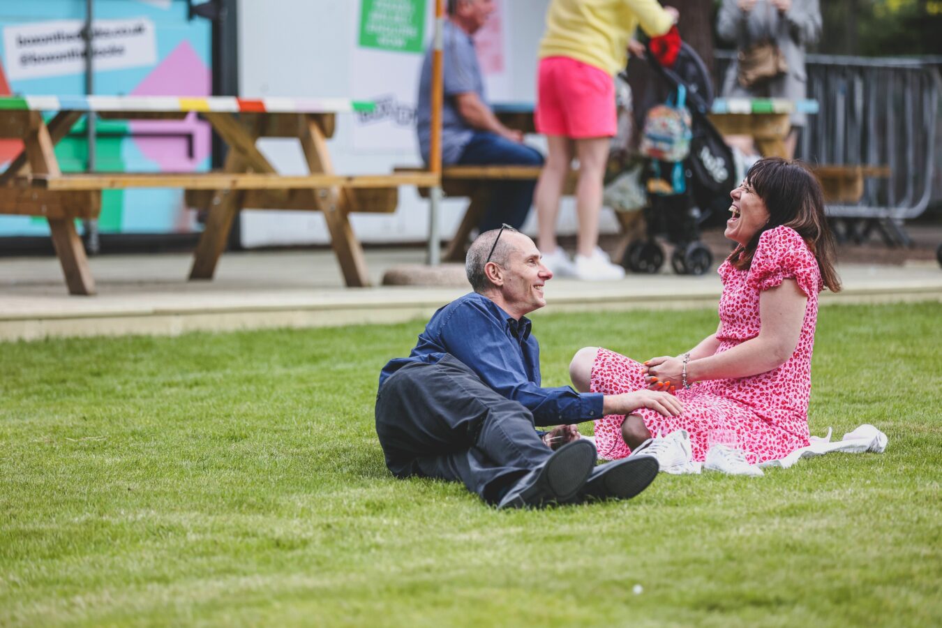 Couple sat laughing on lawn