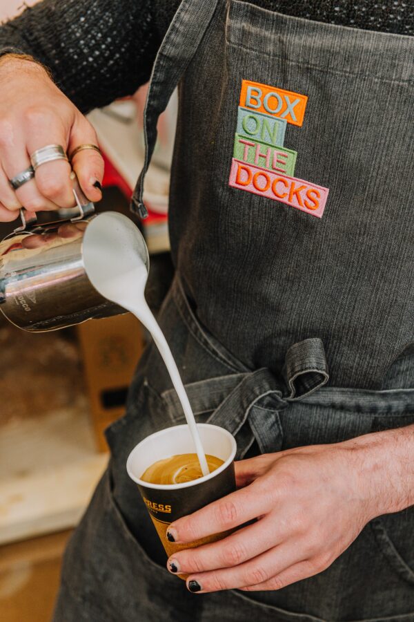 Man pouring milk into coffee